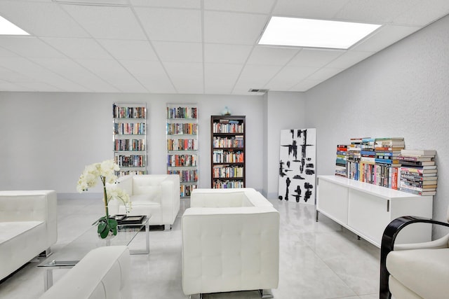 living room with a paneled ceiling