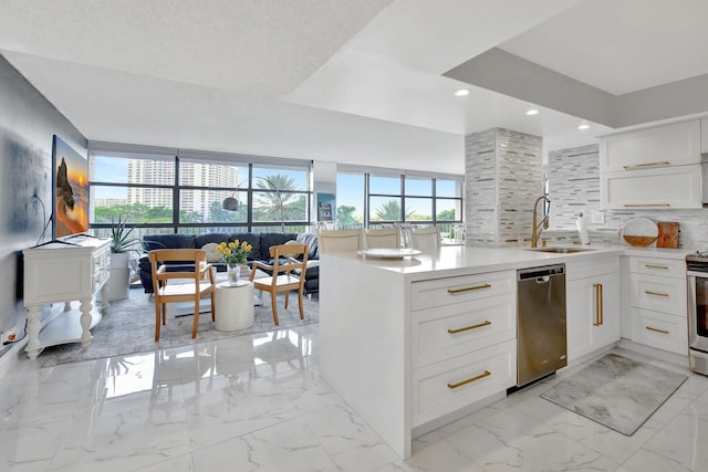 kitchen featuring stainless steel appliances, white cabinetry, tasteful backsplash, and sink