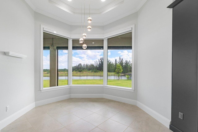 tiled empty room featuring a water view, a tray ceiling, and crown molding