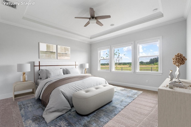 bedroom featuring carpet flooring, ceiling fan, ornamental molding, and a tray ceiling