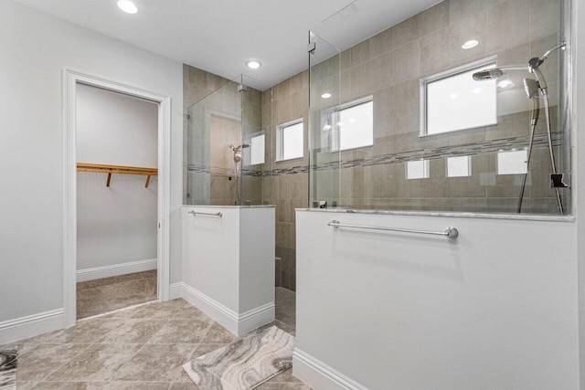 bathroom with a tile shower and tile patterned floors