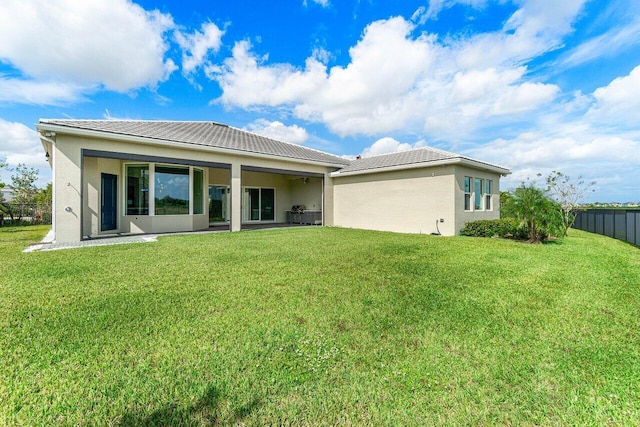 rear view of house featuring a yard