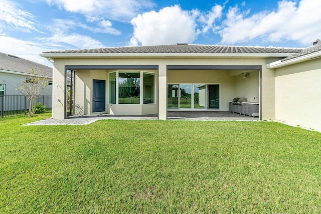 back of property with a lawn and a patio area