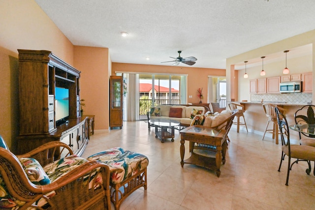 tiled living room featuring a textured ceiling and ceiling fan