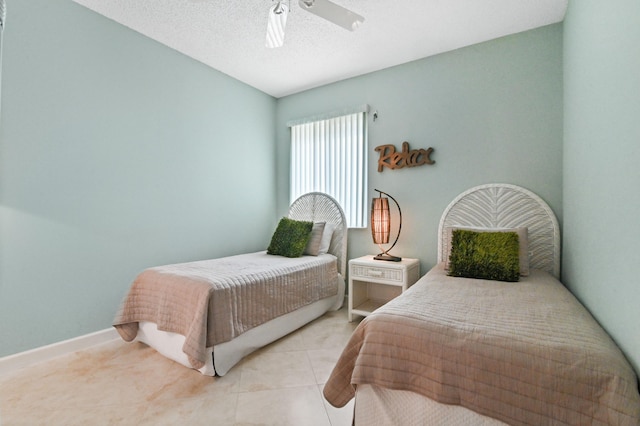 bedroom featuring light tile patterned floors, a textured ceiling, and ceiling fan