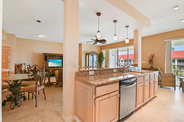 kitchen with light stone countertops, light brown cabinetry, a textured ceiling, and sink