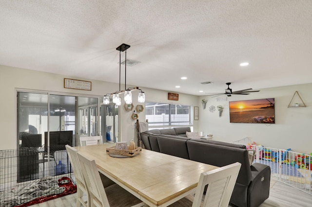 dining area featuring a textured ceiling, ceiling fan, and light hardwood / wood-style flooring