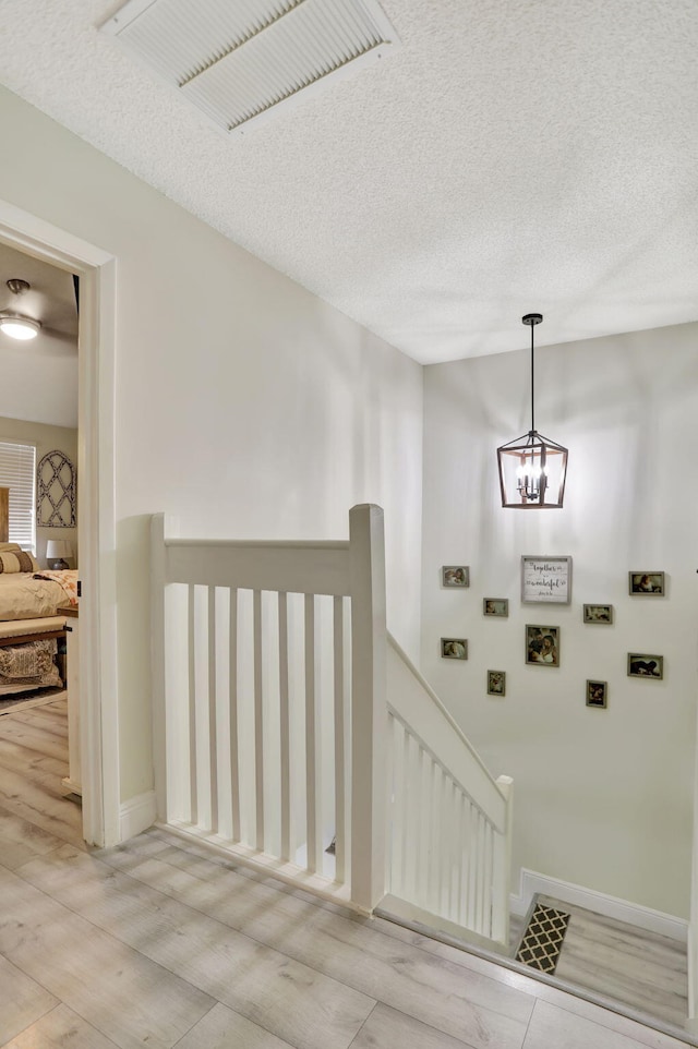 stairway featuring a textured ceiling