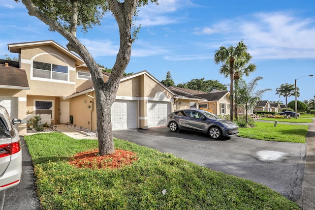 view of front of home with a front yard and a garage