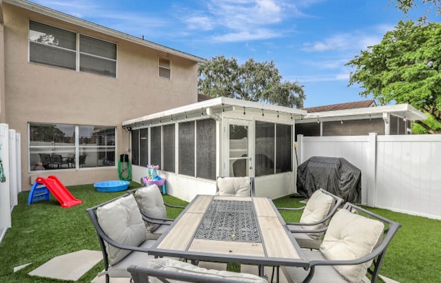 rear view of house with a sunroom and a lawn