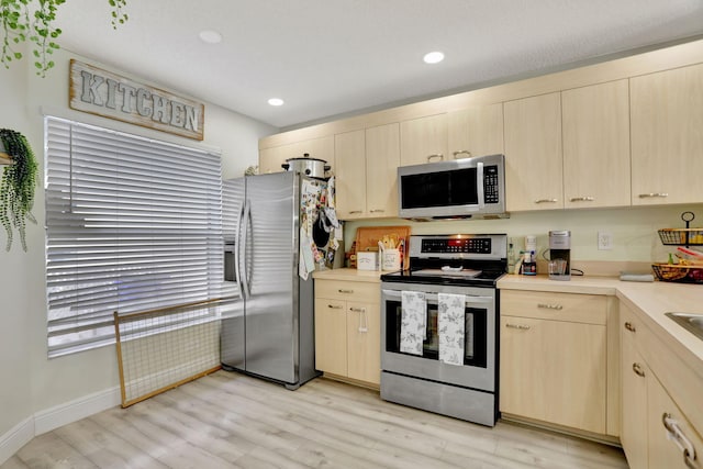 kitchen with light wood-type flooring, appliances with stainless steel finishes, and light brown cabinetry