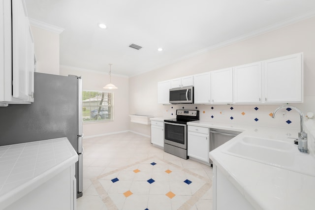 kitchen with crown molding, sink, hanging light fixtures, white cabinetry, and stainless steel appliances