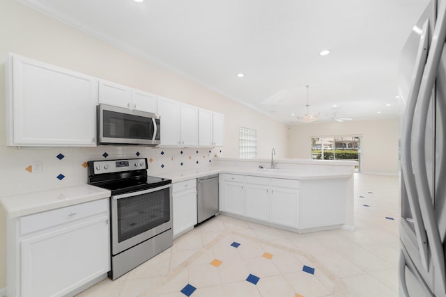 kitchen with sink, stainless steel appliances, tasteful backsplash, kitchen peninsula, and white cabinets