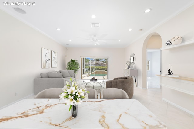 dining area featuring ceiling fan, ornamental molding, and light tile patterned floors