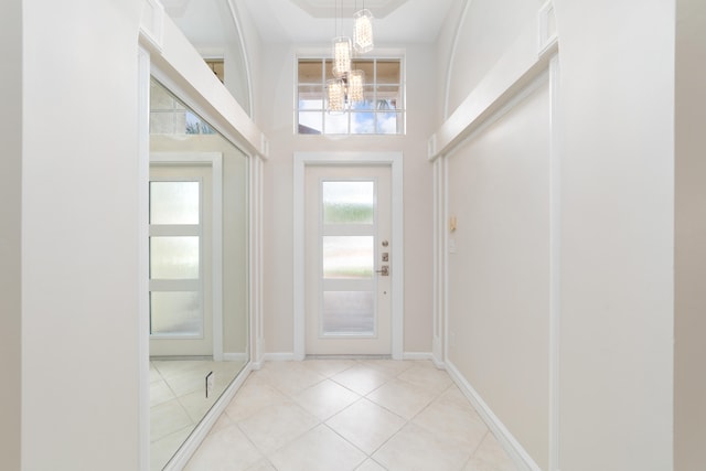 tiled foyer featuring a notable chandelier and a towering ceiling