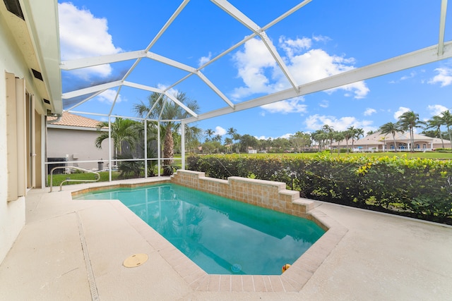 view of swimming pool featuring a patio area and a lanai