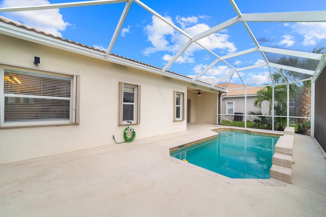 view of swimming pool with a patio area, ceiling fan, and a lanai