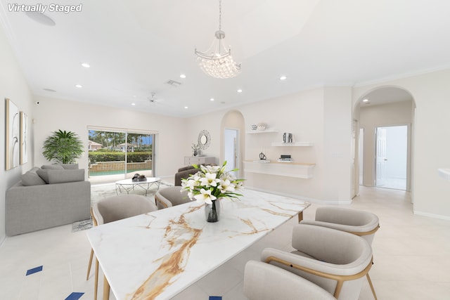 dining area with ceiling fan with notable chandelier, light tile patterned flooring, and ornamental molding