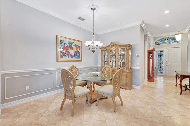 tiled dining area featuring ornamental molding and an inviting chandelier