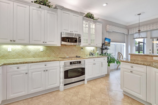 kitchen featuring pendant lighting, backsplash, crown molding, white cabinetry, and stainless steel appliances