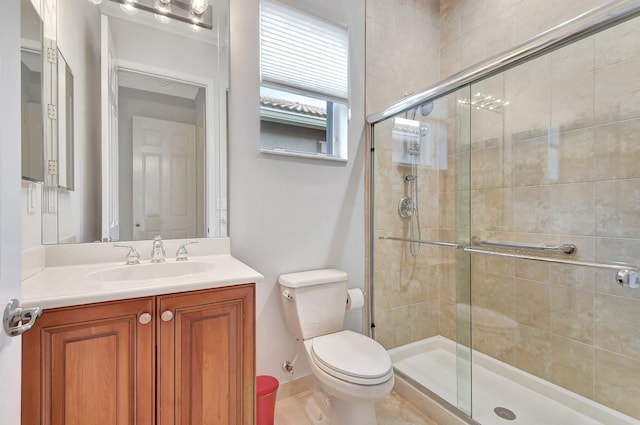 bathroom featuring tile patterned floors, vanity, toilet, and walk in shower