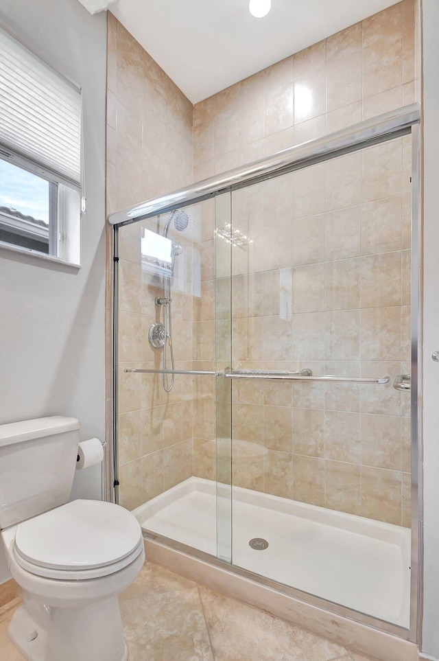 bathroom with tile patterned floors, a shower with shower door, and toilet