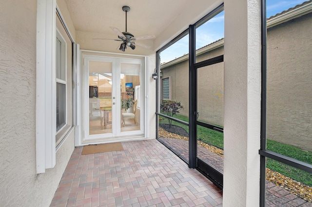 unfurnished sunroom featuring ceiling fan