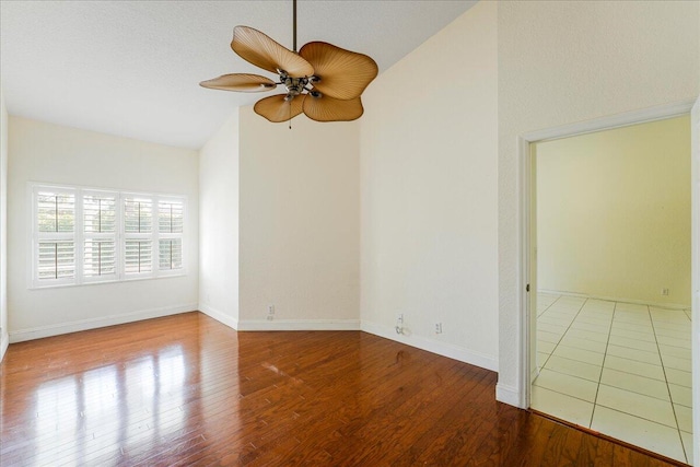 unfurnished room with hardwood / wood-style floors, ceiling fan, a textured ceiling, and vaulted ceiling