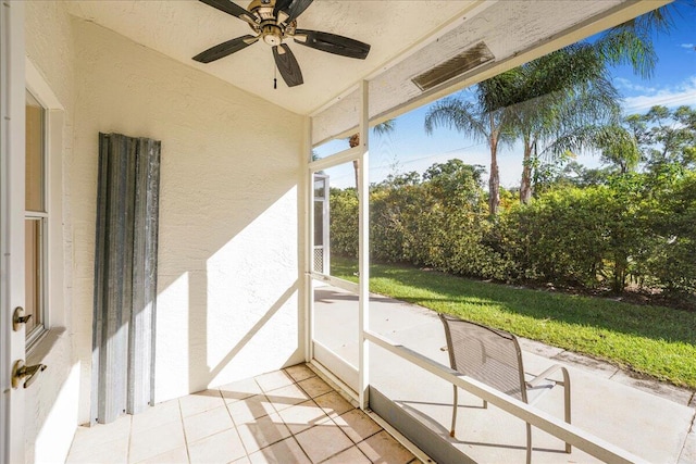 unfurnished sunroom with ceiling fan