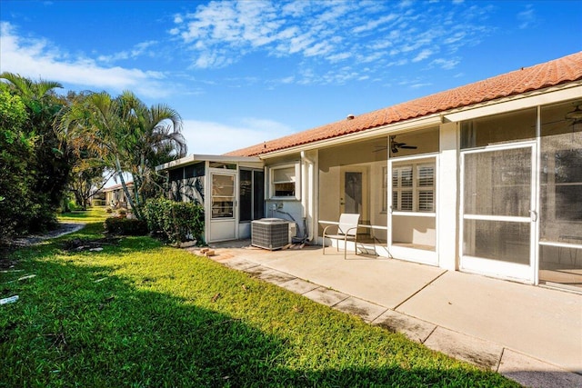 back of property with a sunroom, ceiling fan, a yard, central AC unit, and a patio area