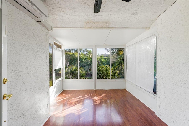 unfurnished sunroom with an AC wall unit and plenty of natural light