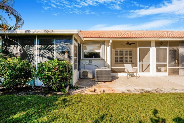 rear view of house with a sunroom, ac unit, cooling unit, ceiling fan, and a yard