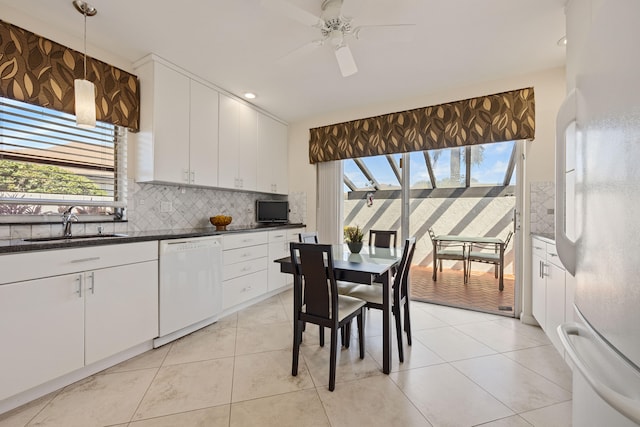 kitchen with white dishwasher, refrigerator, white cabinets, and decorative backsplash