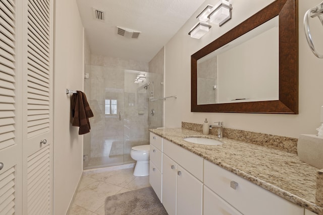 bathroom with vanity, a textured ceiling, toilet, and a shower with door