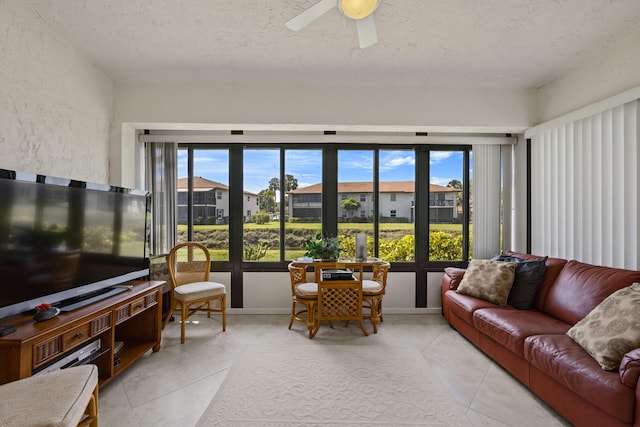 tiled living room with a textured ceiling and ceiling fan