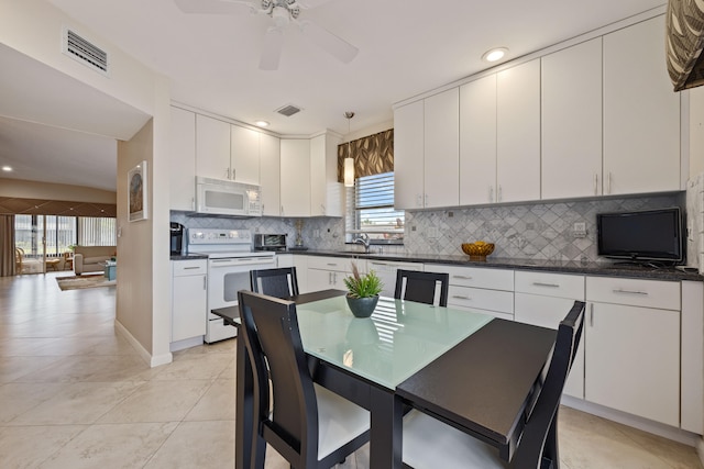 kitchen with white cabinetry, decorative light fixtures, and white appliances