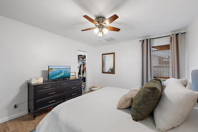 bedroom with a walk in closet and ceiling fan