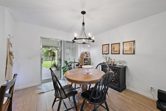 dining space featuring light wood-type flooring and an inviting chandelier