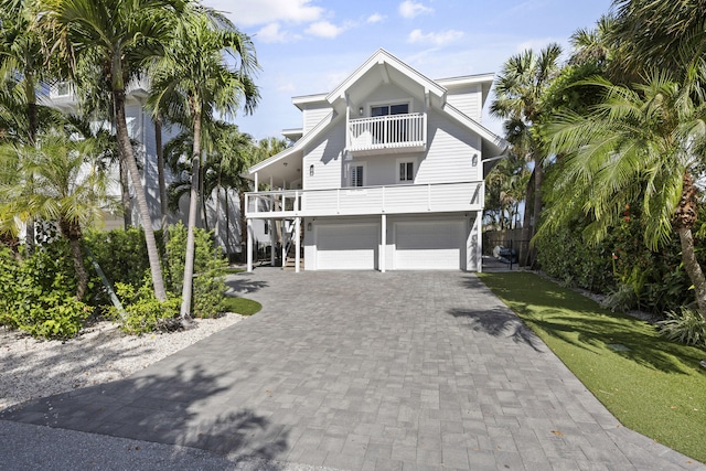 coastal inspired home featuring a garage and a balcony