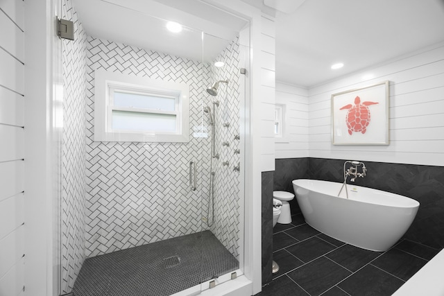 bathroom with tile patterned floors, tile walls, and shower with separate bathtub