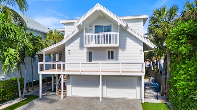 rear view of property featuring a balcony and a garage