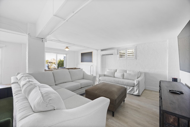 living room with a wall mounted AC and light hardwood / wood-style floors