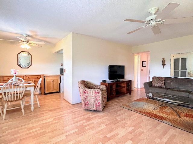 living room with light wood-type flooring and ceiling fan