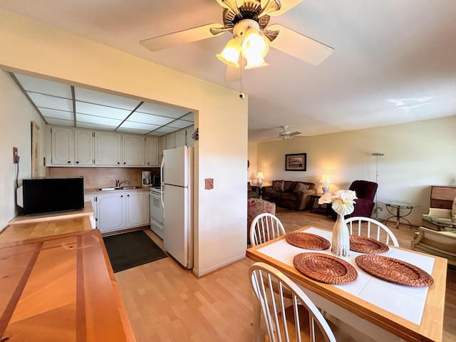 kitchen with sink, ceiling fan, backsplash, light wood-type flooring, and white appliances