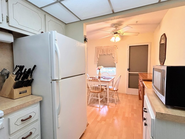 kitchen featuring white cabinetry, light wood-type flooring, ceiling fan, and white refrigerator