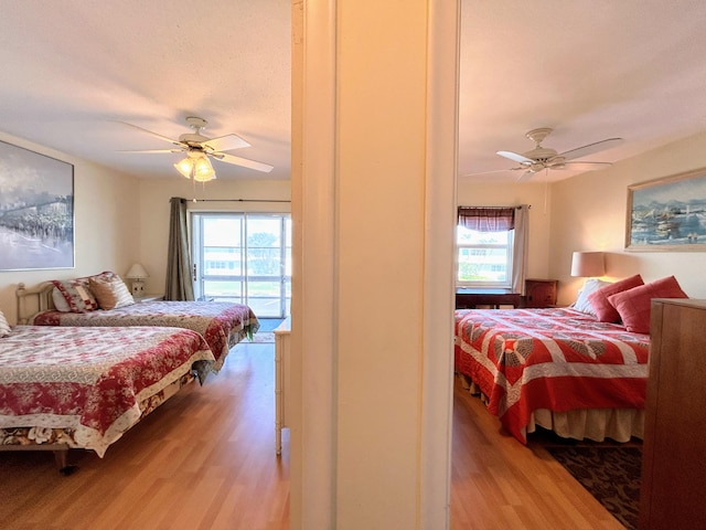 bedroom with ceiling fan, multiple windows, and light hardwood / wood-style floors