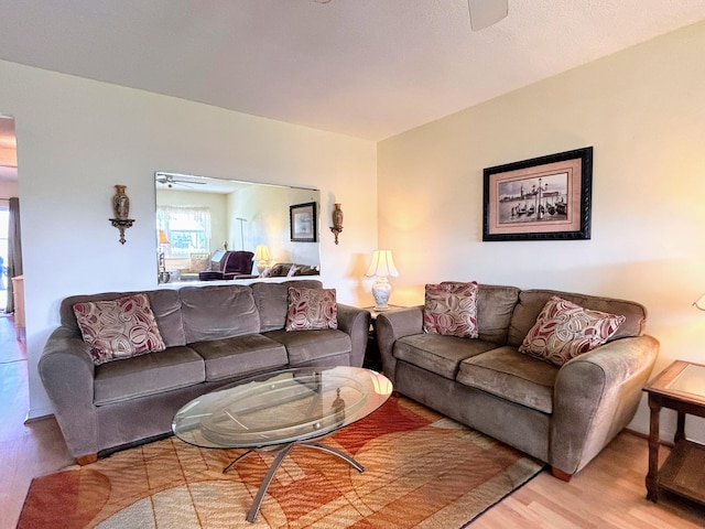 living room with light hardwood / wood-style floors and ceiling fan