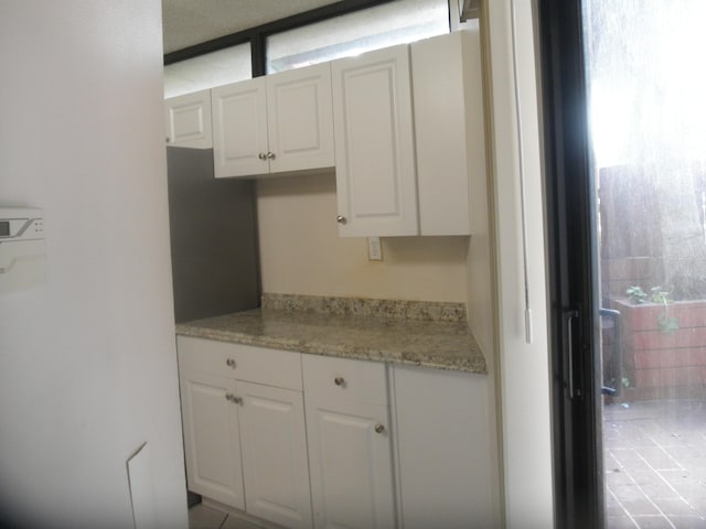 kitchen featuring white cabinetry and light stone countertops