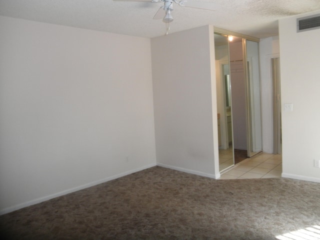 unfurnished room featuring light colored carpet, a textured ceiling, and ceiling fan