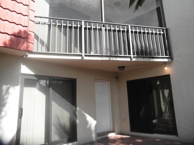 view of exterior entry with a balcony